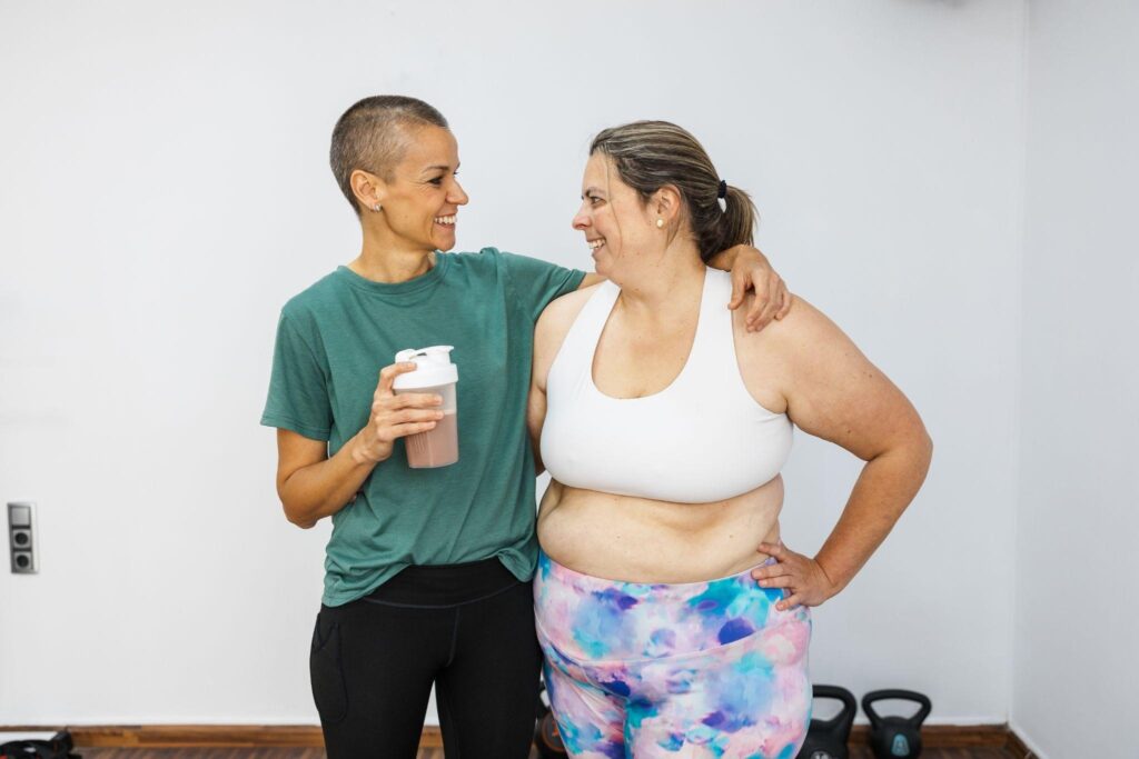 Supportive female weight loss coach smiling with client after session, promoting hormone-friendly weight loss coaching near you.