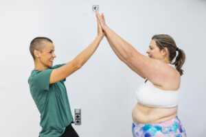 Trainer celebrating progress with client during metabolic weight loss coaching session at Eau Claire weight loss center.