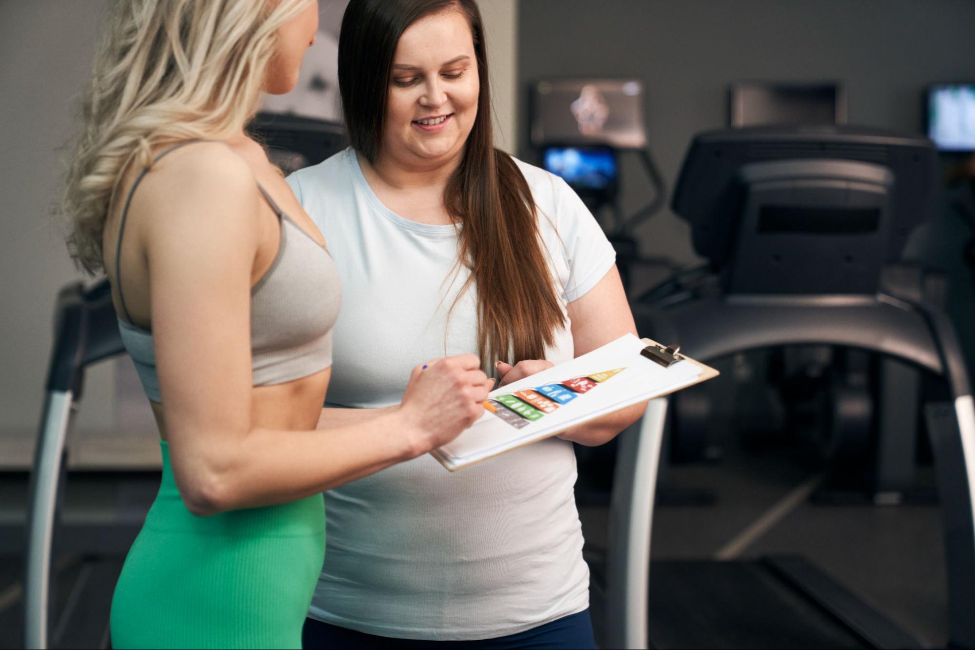 Coach reviewing a personalized food plan with a woman during a metabolism-reset weight loss session in Wisconsin.