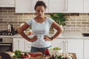 Woman in kitchen preparing fresh vegetables for an anti-inflammatory weight loss meal.